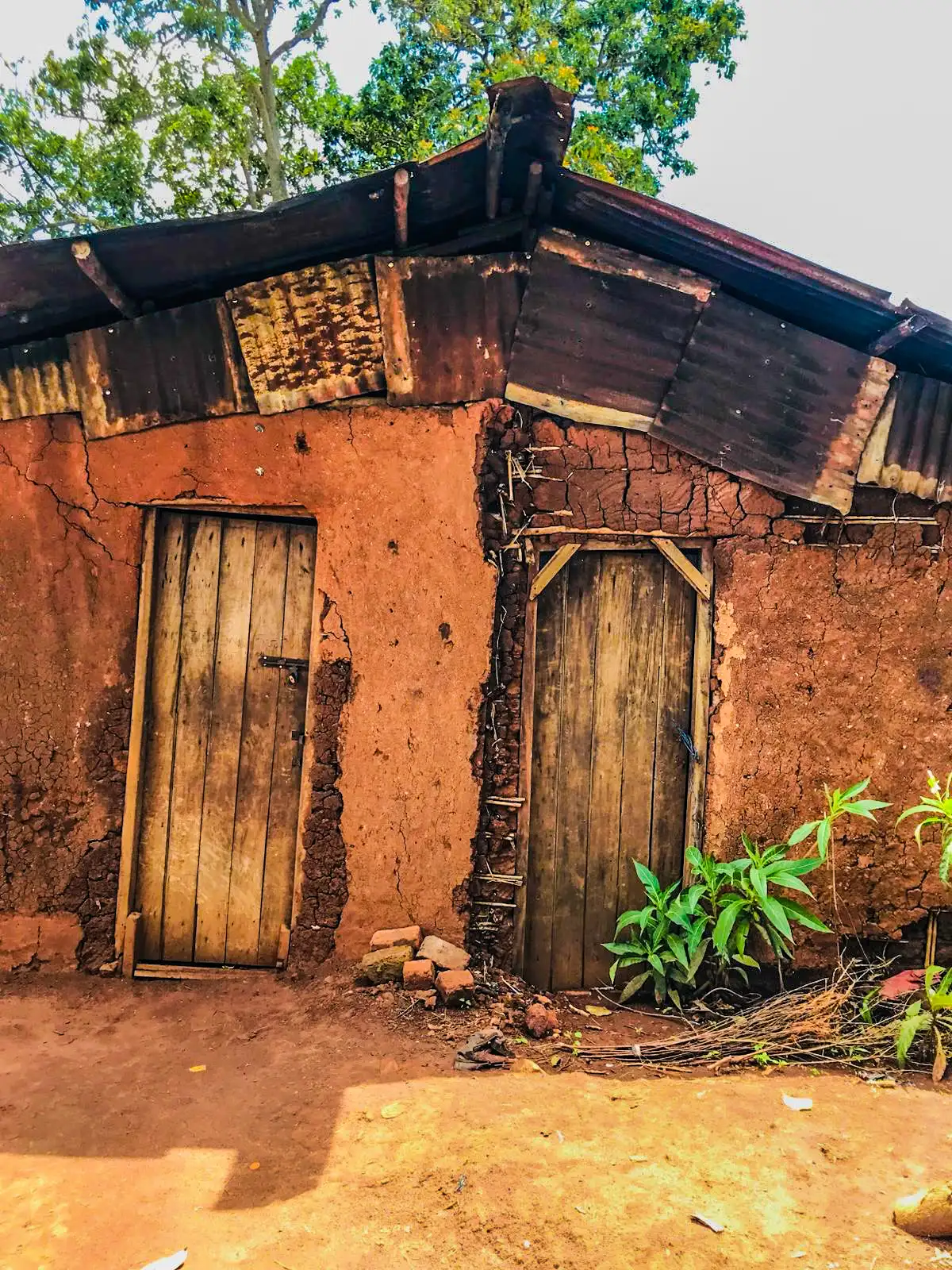 A rural mud-brick home in Uganda with a worn roof, waiting to be made safer and more liveable
