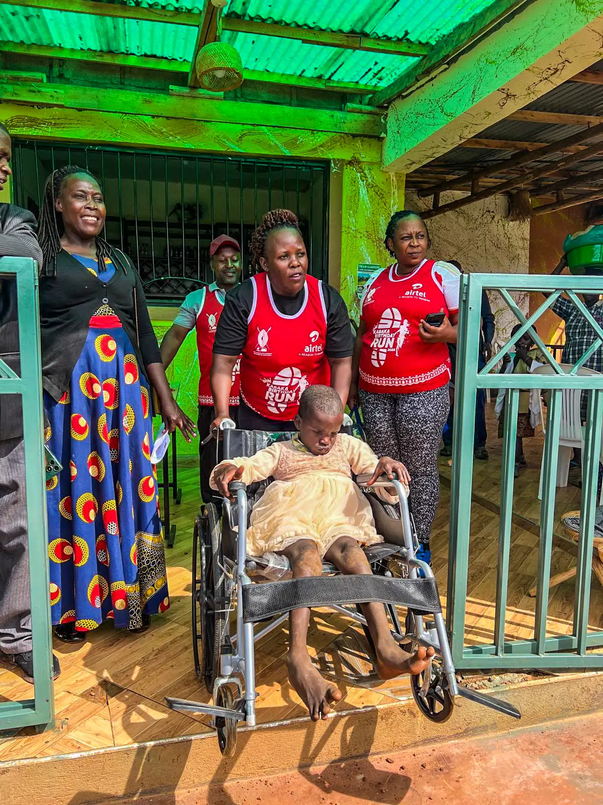 Community members walking with a child in a wheelchair with care and support